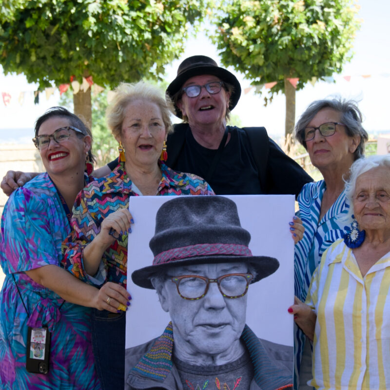 Vier Frauen zeigen ihr fertiges Strickstück.