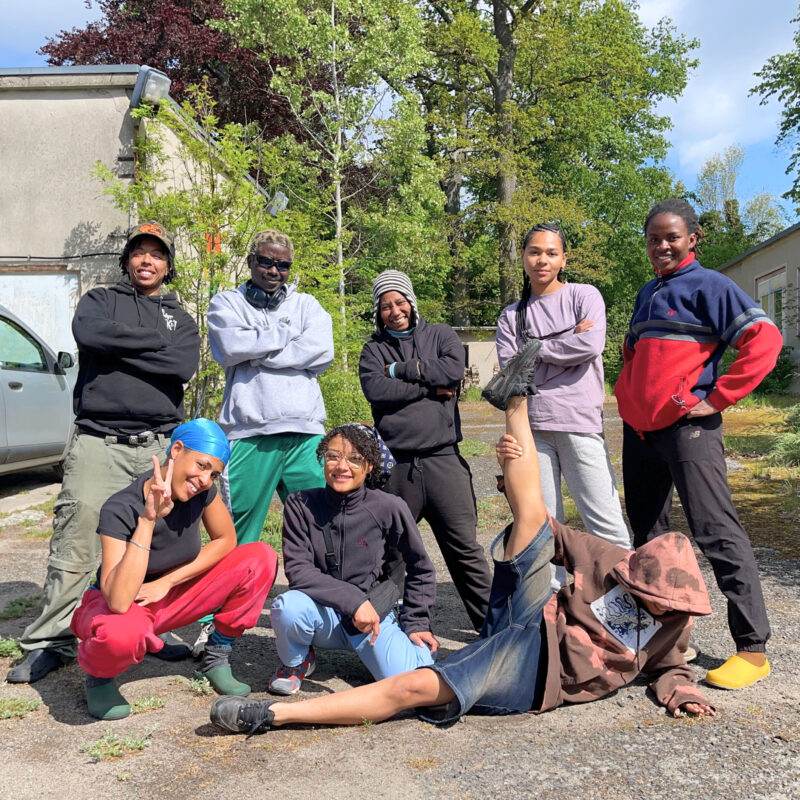 Acht Schwarze junge Menschen posieren für ein Gruppenfoto