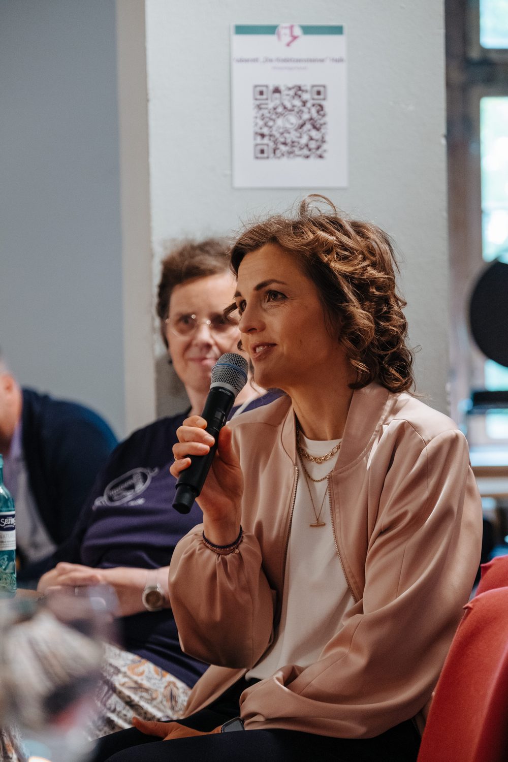 Elisabeth Kaiser spricht auf der Eröffnung der Ausstellung ins Mikrofon.