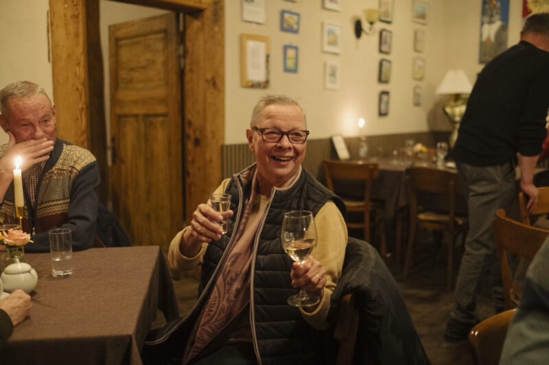 Eine Frau und ein Mann sitzen in einem Gastraum und lachen herzlich.